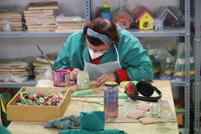 Una mujer desempeña labores de artesanía en un taller