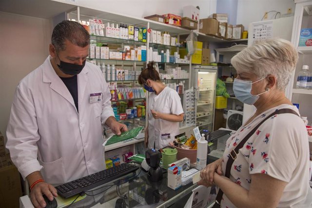 Archivo - Una mujer adquiere las mascarillas en una farmacia. En Sevilla, (Andalucía, España), a 22 de julio de 2020.