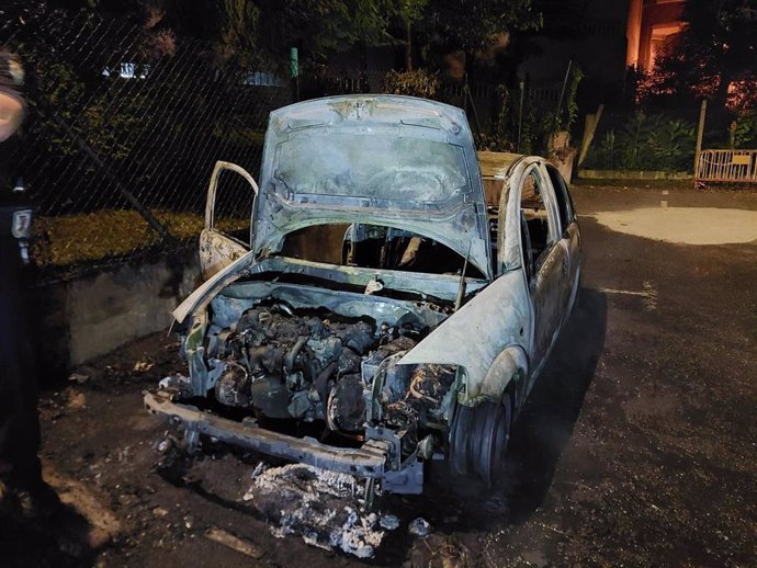 Coche calcinado en un aparcamiento de la calle Pino de Vigo.