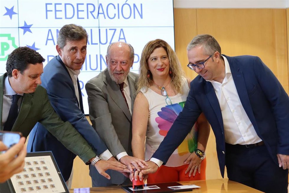 El presidente de la FAMP y la Diputación de Sevilla, Fernando Rodríguez Villalobos, en el centro de la imagen con motivo de la presentación del sello personalizado de Correos dedicado a la Casa Paterri, en Sevilla capital.