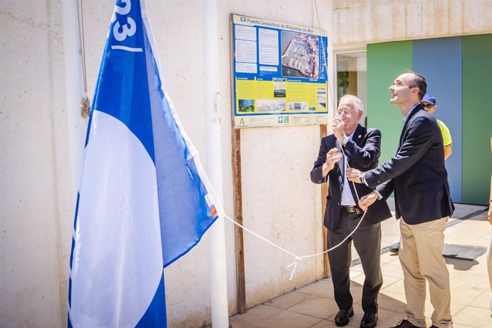 El delegado territorial de Sostenibilidad, Manuel de la Torre, iza la bandera azul del Puerto Deportivo de Roquetas de Mar junto al alcalde del municipio, Gabriel Amat.