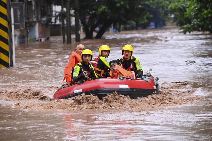 Varias personas en una lancha en una zona inundada de la localidad china de Chongqing 