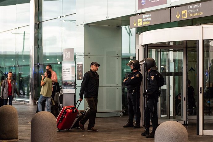 Archivo - Dos agentes de la Policía Nacional fente a una de las puertas de acceso al Aeropuerto de Barcelona- El Prat, donde una multitud se concentra en  protesta por la sentencia del Tribunal Supremo sobre el juicio del 'procés', en Barcelona (España)