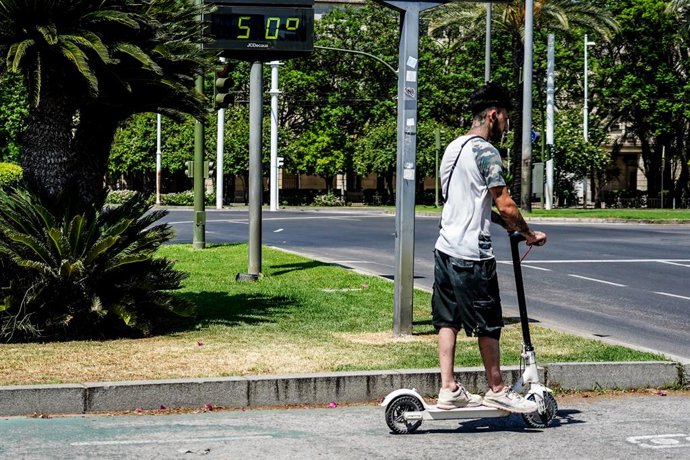 Ciclista pasan por el termómetro situado en el Prado que marca 50 grados, a 26 de junio del 2023 en Sevilla (Andalucía, España). La Agencia Estatal de Meteorología (Aemet) ha activado el aviso rojo por altas temperaturas en las campiñas de Córdoba y Sev