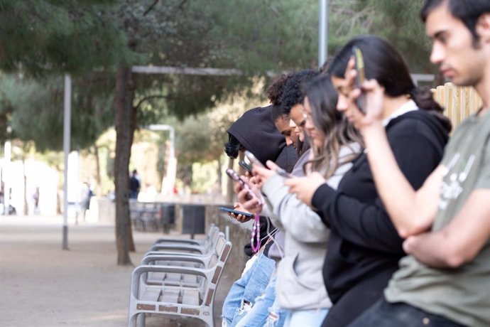 Jóvenes con el móvil, una de las adicciones que trata la Fundación Adsis