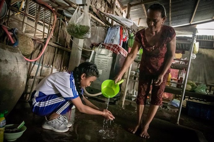Una niña y su abuela distrito con falta de suministro de agua en el distrito de Long Phu, provincia de Soc Trang (Vietnam).