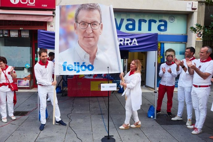 Los candidatos del PP en Navarra al Congreso y el Senado, Sergio Sayas y Amelia Salanueva, despliegan una pancarta con la imagen de Alberto Núñez Feijóo en el acto de inicio de la campaña electoral.