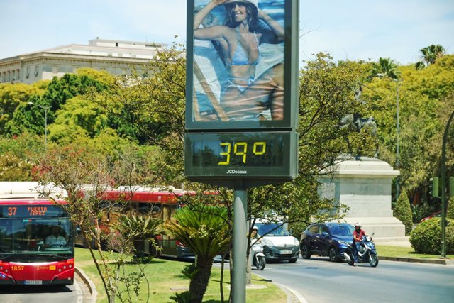 Archivo - Cartelera digital con temperatura que muestra una ola de calor de 39 grados en un cruce de carreteras en el centro de Sevilla en España