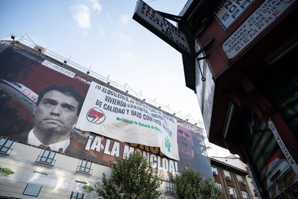 Una nueva lona desplegada por el Movimiento de Vivienda de Madrid encima del cartel de Desokupa, donde se lee Ni alquileres, ni hipotecas, ni deudas. Vivienda gratuita, universal, de calidad y bajo control obrero.