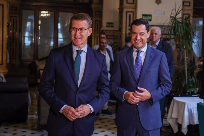 El presidente del PP y candidato a la Presidencia del Gobierno, Alberto Núñez Feijóo (i) junto al presidente de la Junta de Andalucía, Juanma Moreno (d) a su llegada al desayuno informativo, a 7 de julio de 2023, en Sevilla, (Andalucía, España). El pres