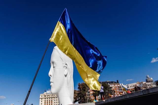 Archivo - Una bandera de Ucrania junto a la escultura 'Julia' de Jaume Plensa en una concentración para pedir el fin de la guerra en Ucrania, en la Plaza de Colón, a 26 de febrero de 2023, en Madrid, (España).