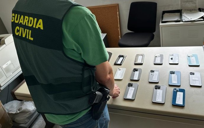 Un agente de la Guardia Civil, con los teléfonos intervenidos.
