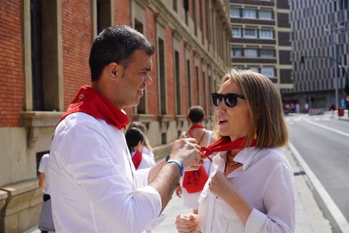 El presidente del PP de Navarra, Javier García, coloca un pañuelo rojo de San Fermín a la secretaria general del PP, Cuca Gamarra.