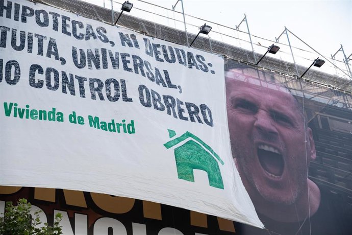 Una nueva lona desplegada por el Movimiento de Vivienda de Madrid encima del cartel de Desokupa, donde se lee Ni alquileres, ni hipotecas, ni deudas. Vivienda gratuita, universal, de calidad y bajo control obrero, a 7 de julio de 2023, en Madrid. 
