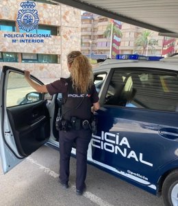 Un agente de la Policía Nacional junto a un vehículo del Cuerpo policial.