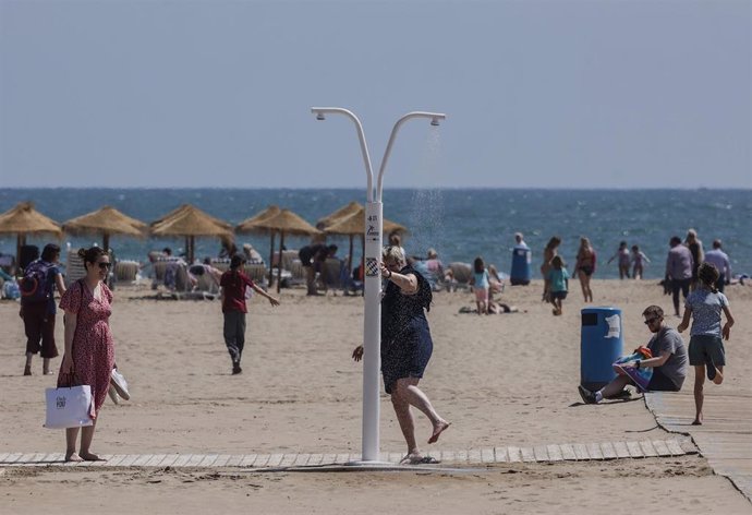 Archivo - Un hombre se quita en una ducha la arena de los pies en la playa de la Malvarrosa, a 26 de abril de 2023