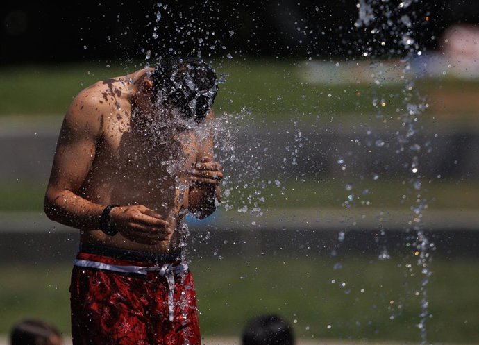 Un chico se refresca en Madrid Rio, a 26 de junio de 2023, en Madrid (España). La Agencia Estatal de Meteorología (Aemet) ha alertado de la primera ola de calor del verano que llega a Madrid con la activación de la alerta roja por meteorología adversa y