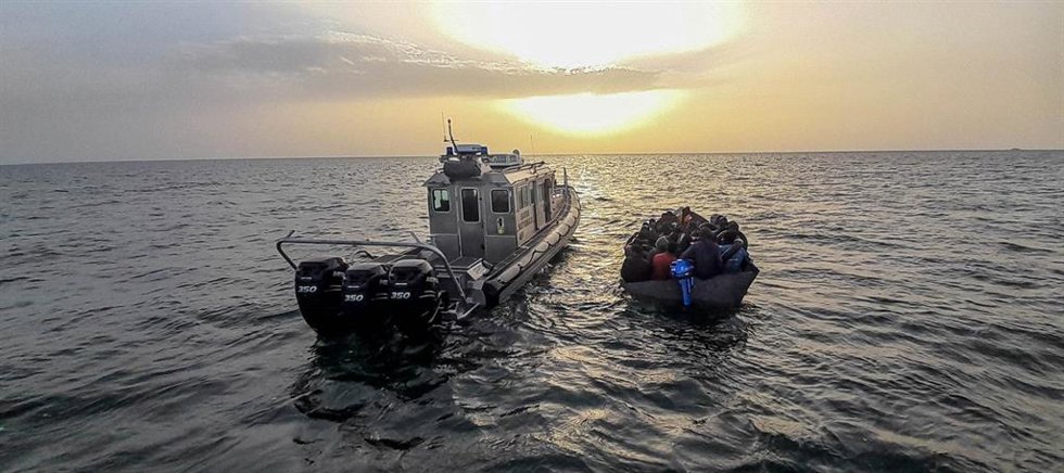 Archivo - Un barco de la Guardia Costera de Túnez junto a una lancha con migrantes