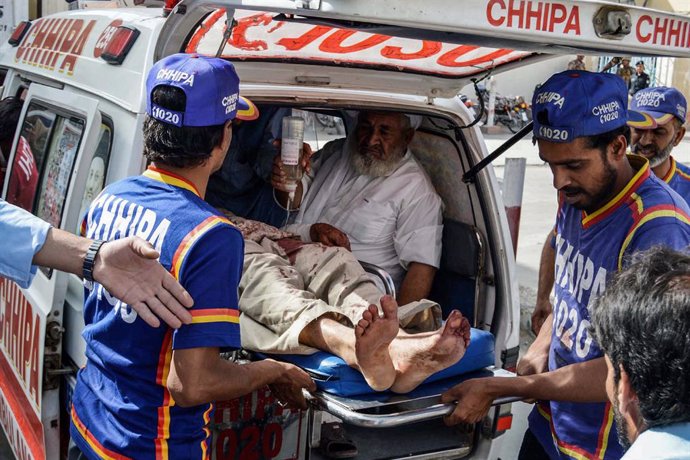 Archivo - 16 August 2019, Pakistan, Kuchlak: An injured man receives first aid in an ambulance. At least two people were killed and more than two dozen wounded when a bomb exploded inside a mosque in south-western Pakistan, officials said, targeting wor