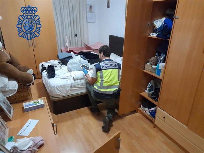 Archivo - Agente de la Policía Nacional en uno de los registros