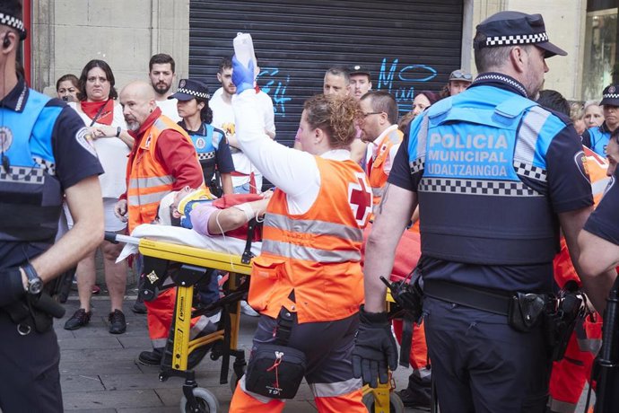 Sanitarios llevan en camilla a un herido en el cuarto encierro de las fiestas de San Fermín 2023