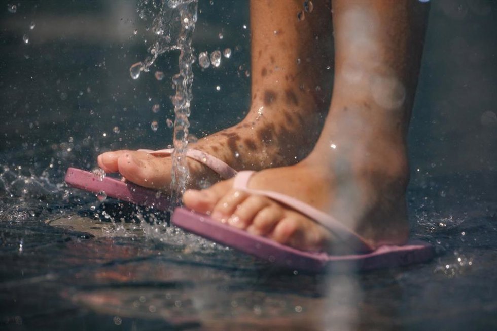Una niña juega en el agua para refrescarse en Madrid Río