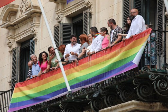 Los grupos políticos despliegan la pancarta con los colores LGTBI en el balcón del Ayuntamietno de Alicante.