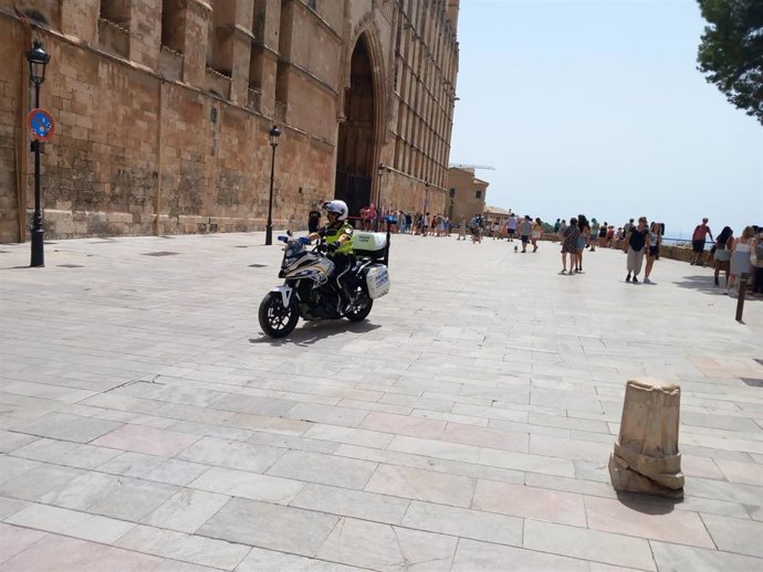 Archivo - Un agente de la Policía Nacional, en moto, en las inmediaciones de la Catedral de Mallorca.