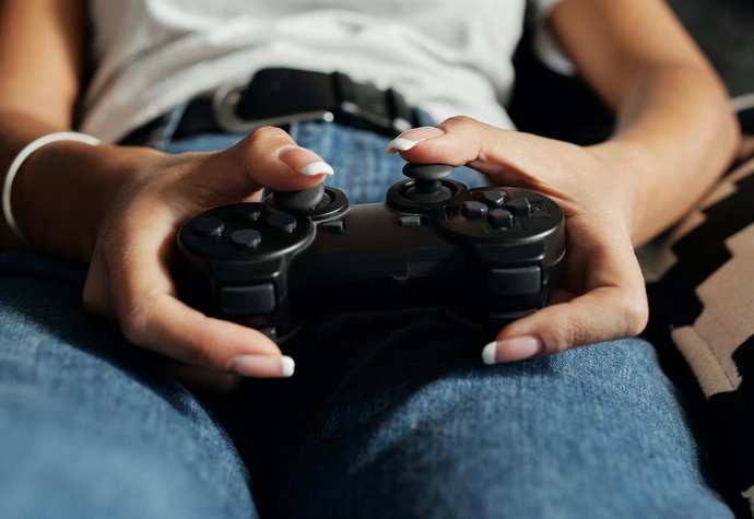 Una mujer utilizando el mando de la PlayStation