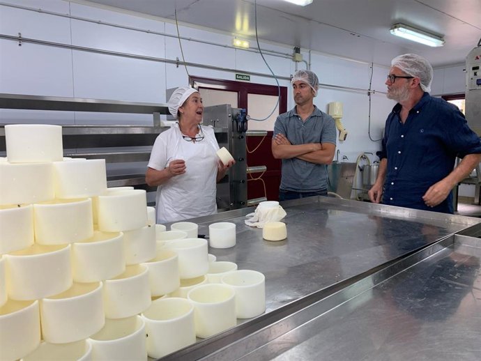 El candidato de Sumar al Congreso, Rafael Cofiño, acompañado de Diego Ruiz de La Peña, también candidato al congreso, con una de las responsables de la quesería Bedón.