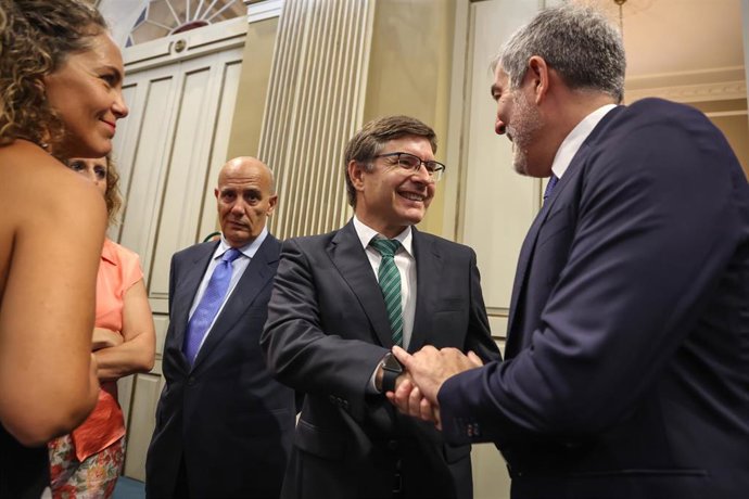 El portavoz de Vox en el Parlamento de Canarias , Nicasio Galván, saluda al candidato a presidente del Gobierno de Canarias, Fernando Clavijo (CC), durante el pleno de investidura en el Parlamento de Canarias, a 11 de julio de 2023