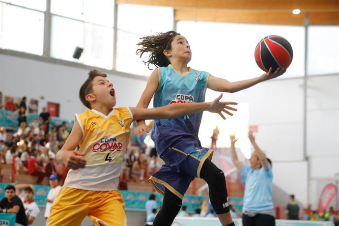Archivo - Niños jugando a baloncesto.