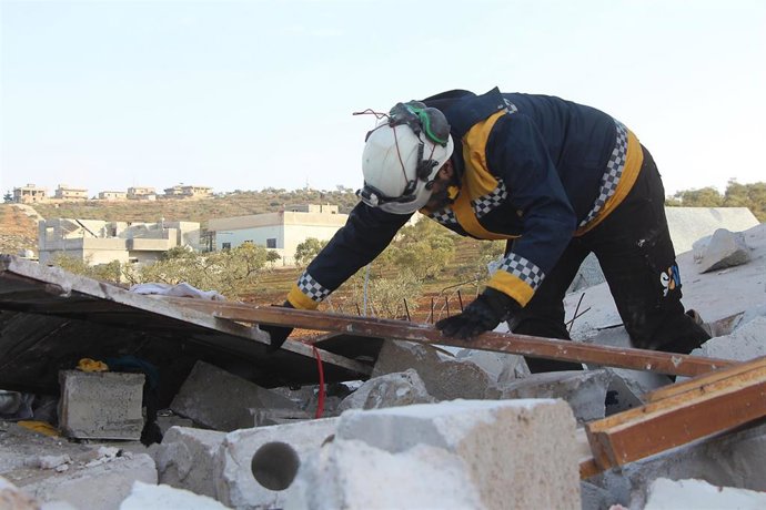 Archivo - Un miembro de la organización Defensa Civil Siria (SCD), conocida como 'cascos blancos', inspecciona un edificio tras un bombardeo