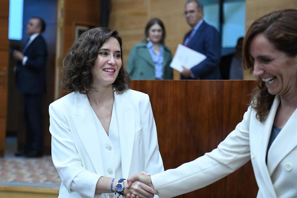 La presidenta en funciones de la Comunidad de Madrid, Isabel Díaz Ayuso (i), saluda a la portavoz de Más Madrid en la Asamblea, Mónica García.