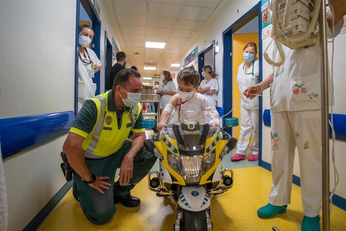 Menores hospitalizados reciben una moto de la Guardia Civil para recorrer los pasillos de Pediatría.