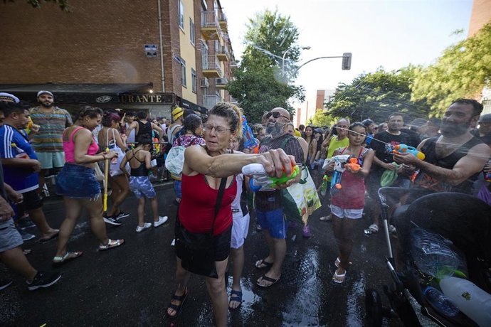 Archivo - Varias personas disfrutan del agua durante la celebración de la Batalla Naval, uno de los atractivos de las Fiestas Patronales de la Virgen del Carmen en el distrito de Puente de Vallecas, a 17 de julio de 2022, en Madrid (España).