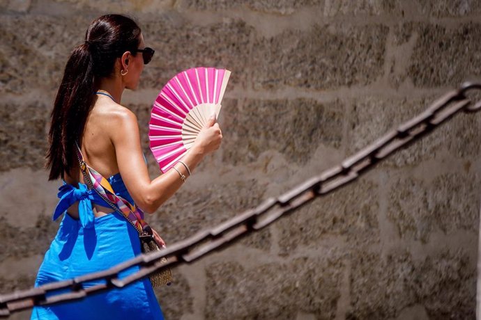 Una  turista con un abanico en la mano en juna imagen de archivo 