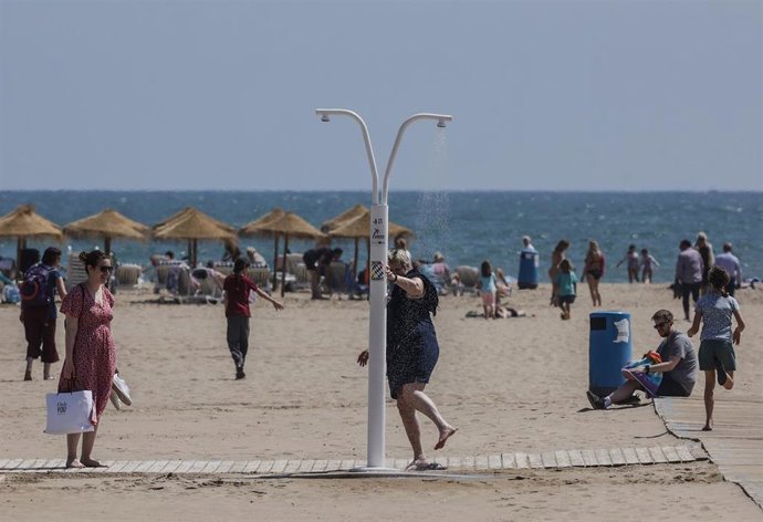 Archivo - Un hombre se quita en una ducha la arena de los pies en la playa de la Malvarrosa