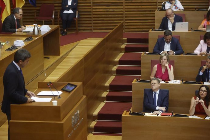 El presidente en funciones de la Generalitat, Ximo Puig, observa el discurso de su sucesos, el candidato del PPCV, Carlos Mazón, durante el pleno de investidura en las Corts Valencianes