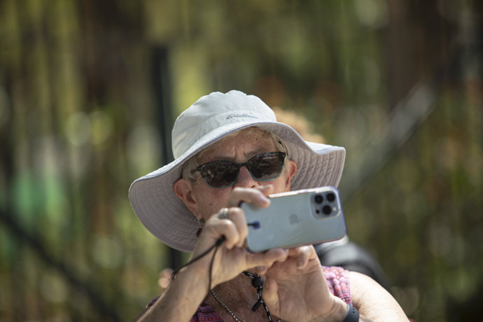 Una turista con sombrero y gafas de sol debido a las cálidas temperaturas. A 10 de Abril de 2023, en Sevilla (Andalucía, España).