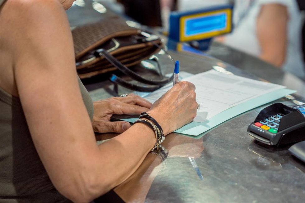 Una persona rellena unos documentos tras solicitar el voto por correo