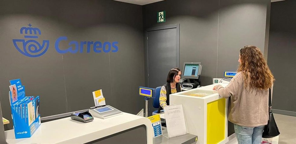 Archivo - Imagen de una mujer siendo atendida en una oficina de correos.