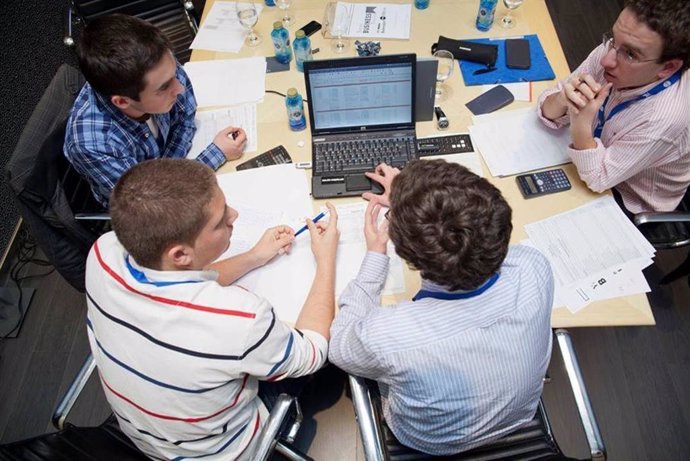 Archivo - Jóvenes estudiantes consultan un ordenador