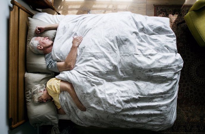 Archivo - Pareja durmiendo en la cama.