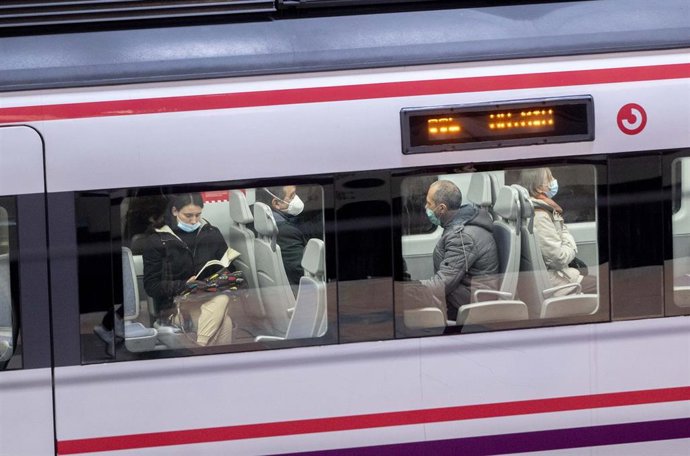 Archivo - Varias personas con mascarilla dentro de un tren