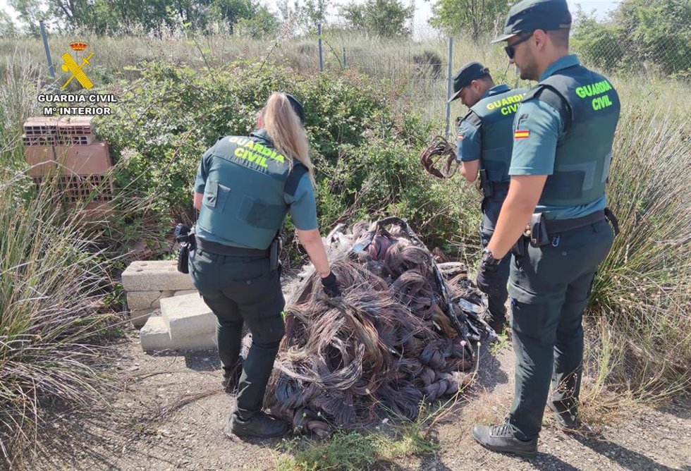 Hoguera apagada con restos de cable de cobre.