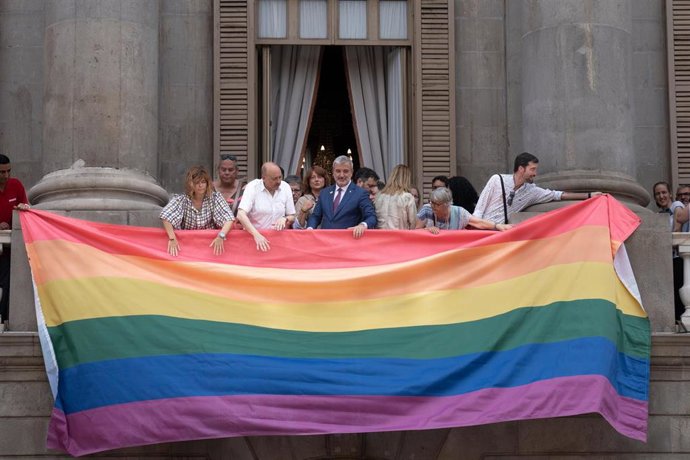 El alcalde de Barcelona, Jaume Collboni (4d), ayuda a colgar la bandera LGTBIQ+  durante el Día Internacional del Orgullo en el Ayuntamiento de Barcelona, a 28 de junio de 2023, en Barcelona, Catalunya (España). 