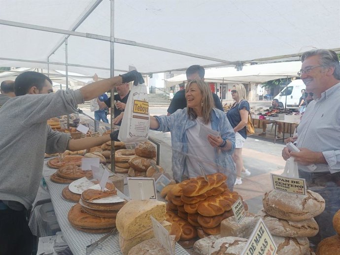 La cabeza de lista del PP al Congreso por Asturias, Esther Llamazares, y el candidato al Senado del PP Pablo González, durante una visita al mercado de Pola de Lena