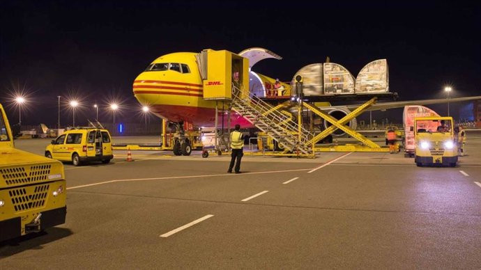 Un avión de transporte de mercancías de la compañía DHL, con operarios realizando labores de carga, en una imagen de archivo.