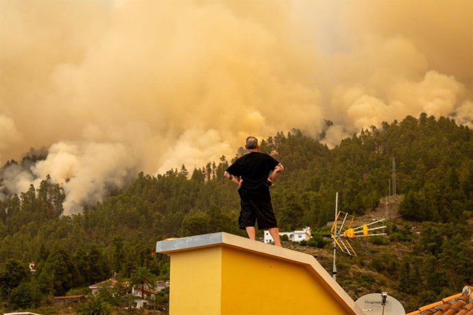 Un veí observa des de la teulada d'una casa l'incendi forestal declarat a La Palma, a 15 de juliol del 2023, a Puntagorda, La Palma, Canries